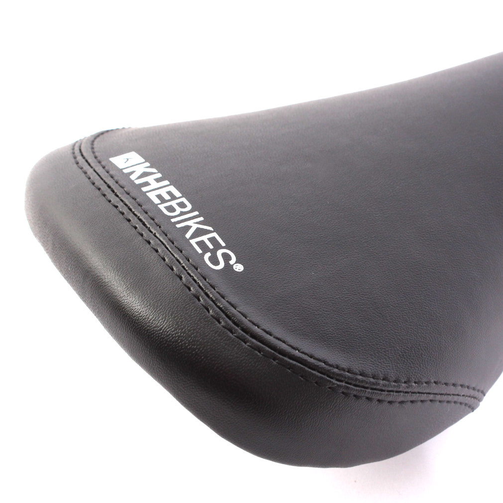 Nahaufnahme weißer KHEBikes Schriftzug auf schwarzem Kunstleder Sattel